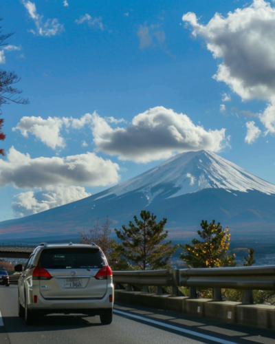 A car driving on a highway in Osaka, Japan with Mount Fuji in the background