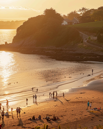 Families and children enjoying a sunset picnic on a sandy beach in Dunmore Town.